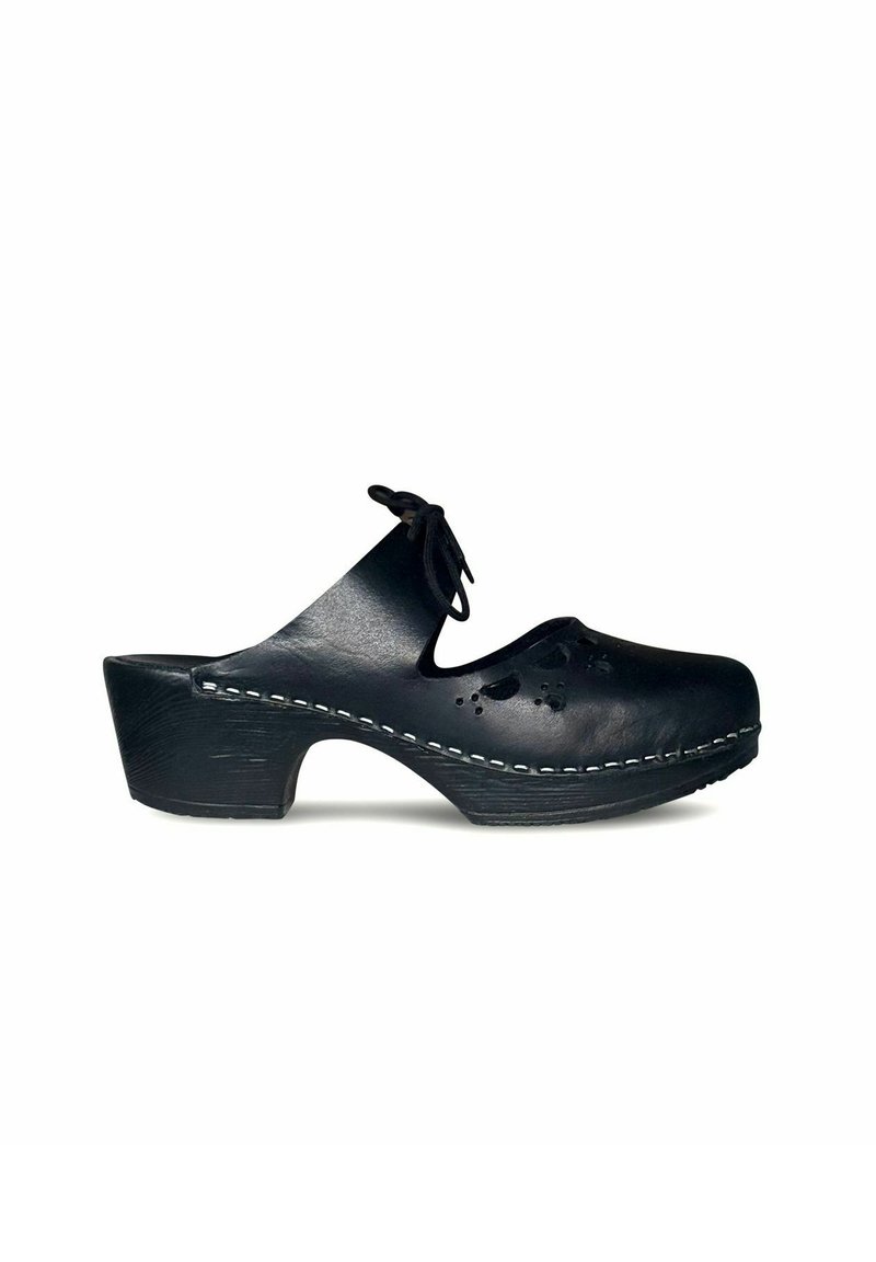 Zwarte leren klomp met een gebogen hak, uitsnijdingen in bloemdesign en witte stiksels langs de zool. Bevat een strik aan de voorkant.