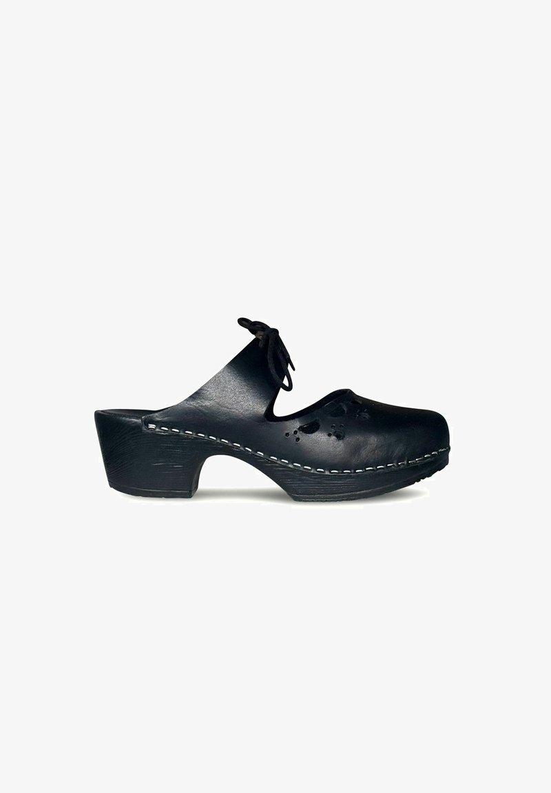 Zwarte leren klomp met een gebogen hak, uitsnijdingen in bloemdesign en witte stiksels langs de zool. Bevat een strik aan de voorkant.