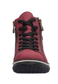 Bottine en cuir rouge jusqu'à la cheville avec des lacets noirs, des zips latéraux, une semelle en caoutchouc texturée et une bande blanche à la base. Présente des coutures renforcées.