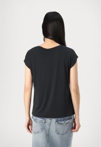 Chemise noire à manches courtes avec un col arrondi, une texture lisse et une coupe décontractée, associée à une jupe en denim bleu clair avec des poches arrière.