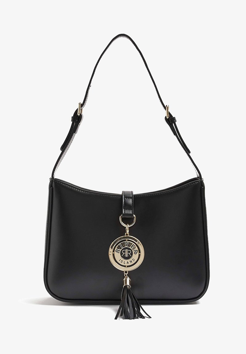 Sac à épaule en cuir noir avec bandoulière ajustable, breloque circulaire dorée avec le logo River Island, et gland en cuir noir suspendu à l'avant.