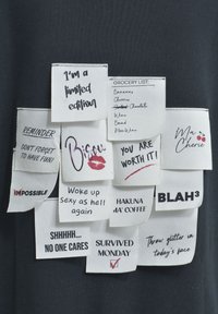 Stoffetiketten mit verschiedenen motivierenden und humorvollen Sprüchen, darunter "Ich bin eine limitierte Auflage", "Du bist es wert" und ein durchgestrichenes "Unmöglich".