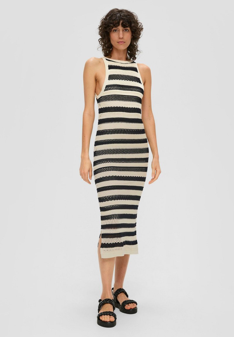 Robe midi en tricot avec une silhouette ajustée, présentant des rayures horizontales alternées en noir et crème, des fentes sur les côtés et un design sans manches.