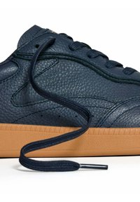 Zapatillas de cuero azul marino con un acabado texturizado, cordones planos en azul marino y una suela de goma color caramelo que presenta un patrón triangular.