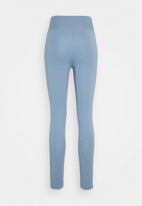 Leggings azzurri con una cintura ampia, texture liscia e design aderente che si restringe fino alle caviglie. Senza motivi visibili o decorazioni.