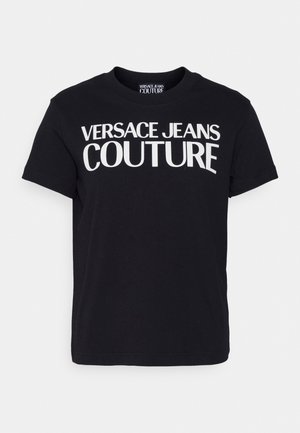 T-shirt en coton noir avec un texte blanc audacieux "VERSACE JEANS COUTURE" sur le devant, doté d'un col rond classique et de manches courtes.