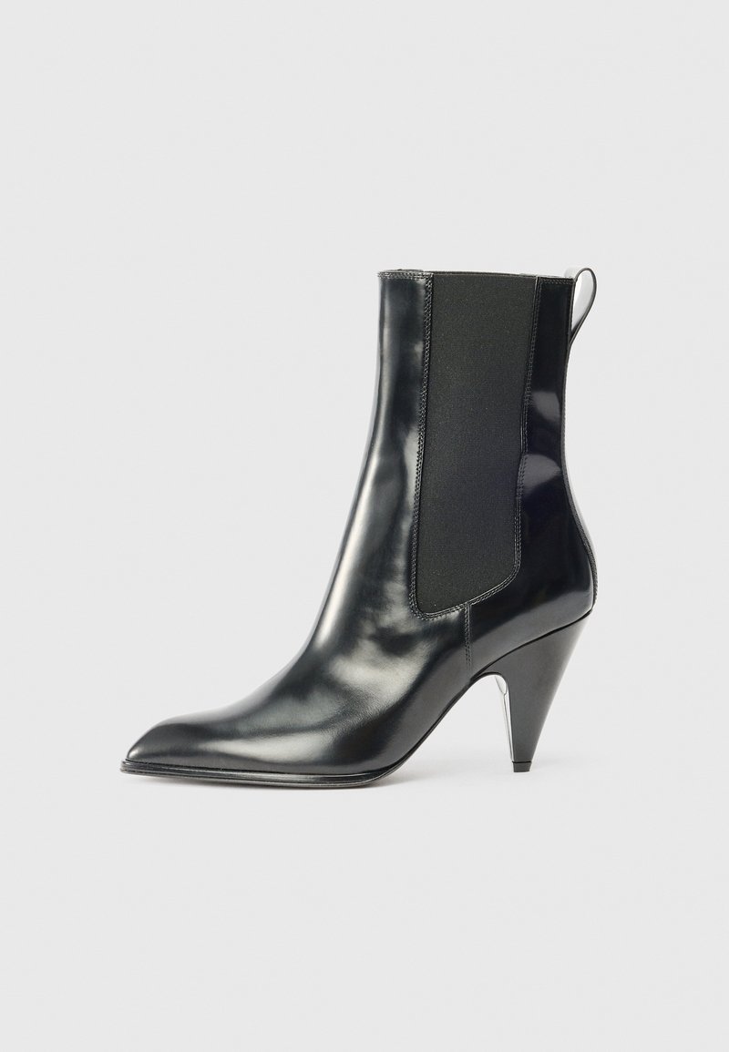 Μαύρη γυαλιστερή δερμάτινη μπότες μέχρι τον αστράγαλο με μυτερή μύτη, ελαστική πλευρική επένδυση, θηλιά στο πίσω μέρος και μεσαίου ύψους κωνικό τακούνι.