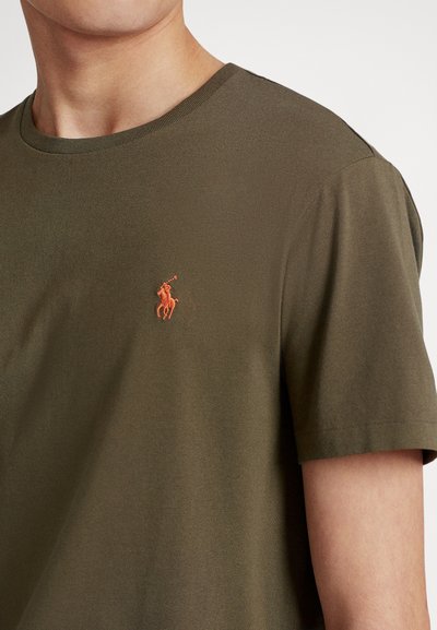 Olive green t-shirt made of soft cotton, featuring a crew neck and a small orange polo logo embroidered on the chest.