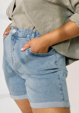 Shorts in denim blu chiaro con orli arrotolati, design a cinque tasche e chiusura con bottone. Il tessuto ha un'aspetto sbiadito e testurizzato.