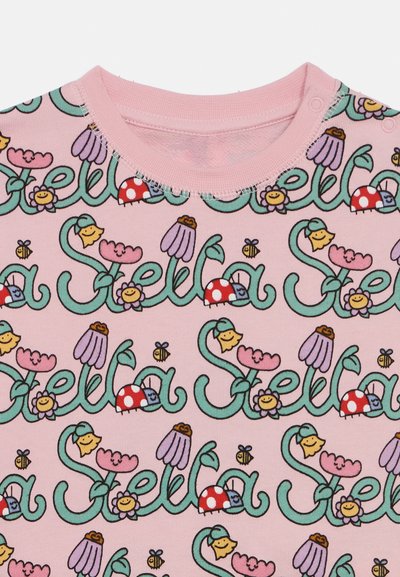 Svetloružový bavlnený top s hravým potlačom usmievajúcich sa kvietkov, húb, včiel a mena "Stella" v tyrkysovej farbe. Krátke rukávy a okrúhly výstrih.