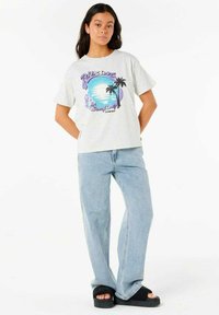 Grå grafisk t-shirt med et farverigt kystdesign med palmer. Sammen med lyseblå straight-leg jeans og sorte slidesandaler.