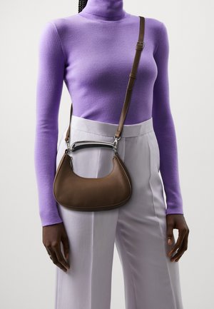 Ruskea nahkalaukkua, jolla on kaareva muoto, hopeanvärisiä yksityiskohtia ja irrotettava olkahihna. Yhdistetty violettiin poolopaitaan ja vaaleisiin housuihin.