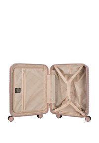 Hard-shell kufr v růžově zlaté barvě, s prošívaným povrchem, dvojitými přihrádkami, síťovou kapsou na zip a nastaviteľnými popruhy pro bezpečné balení.