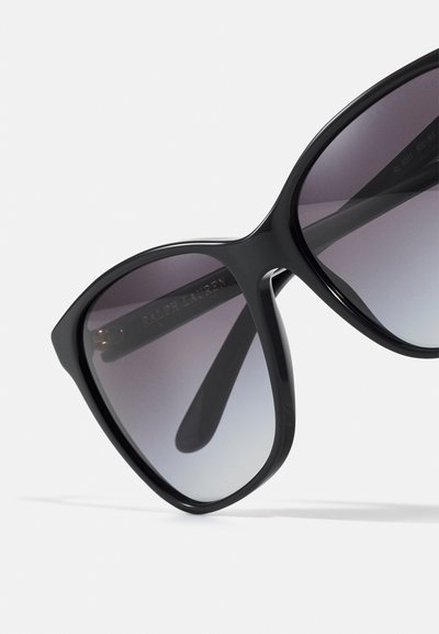 Black oversized sunglasses with gradient lenses and sleek edges. The frame features subtle branding on the temple.