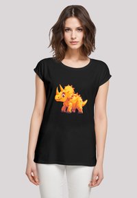 Schwarzes T-Shirt mit hochgerollten Ärmeln, das ein buntes, cartoonartiges Grafikdesign eines orangefarbenen Triceratops auf der Vorderseite zeigt. Weicher Stoff.