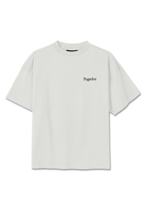 Valge lühikeste varrukatega ümara kaelusega t-särk, mille vasakule rinnale on trükitud väikesed mustad tähed "Pegador".