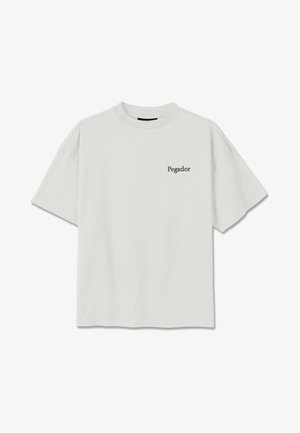 Valge lühikeste varrukatega ümara kaelusega t-särk, mille vasakule rinnale on trükitud väikesed mustad tähed "Pegador".