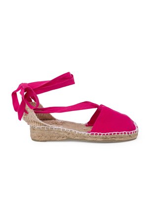 Espadrille de lona rosa con suela de yute, que presenta cintas cruzadas en el tobillo y un borde blanco cosido a lo largo de la suela.