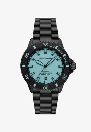 Černé nerezové potápěčské hodinky s tyrkysovým ciferníkem, luminiscenčními ukazateli, otočným rámečkem a zobrazením data. Voděodolné do hloubky 200 metrů.