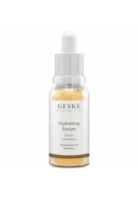Transparante glazen fles met een zilveren dop, gevuld met een lichtgele hydraterende serum. Het etiket heeft zwarte tekst op een witte achtergrond.