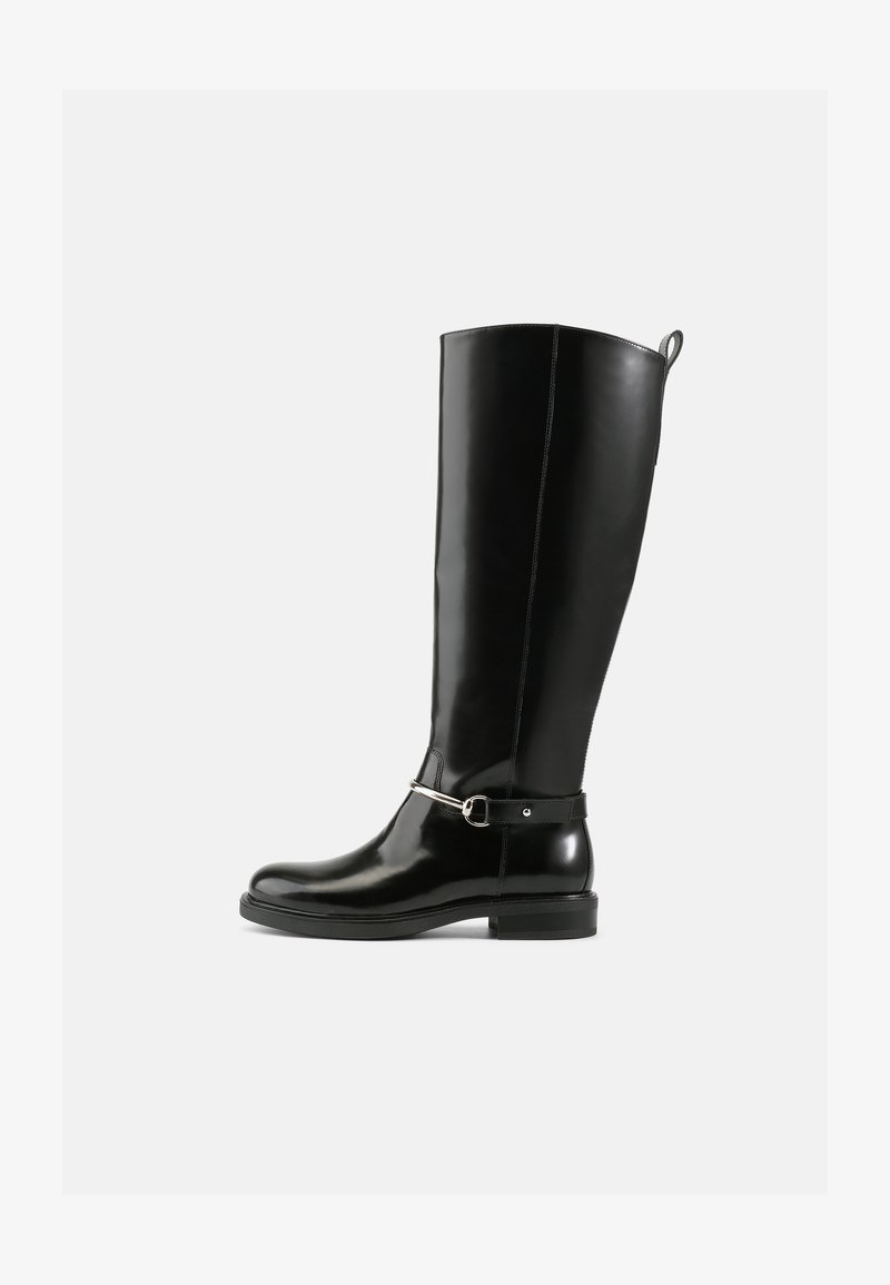 Botas de couro pretas brilhantes até ao joelho com um design simples, apresentando uma corrente e fivela de metal prateado perto do tornozelo. Sola de borracha plana.