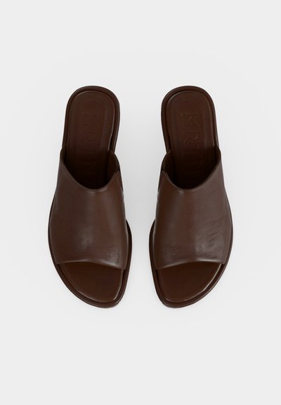 Pair of brown leather open-toe slip-on sandals with a wide upper strap and flat soles, viewed from above on a light background.