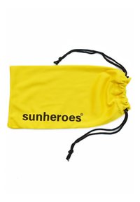 Gul tygpåse med dragsko som har svart text "sunheroes", slät yta och en dragningsöppning med svarta snören för stängning.