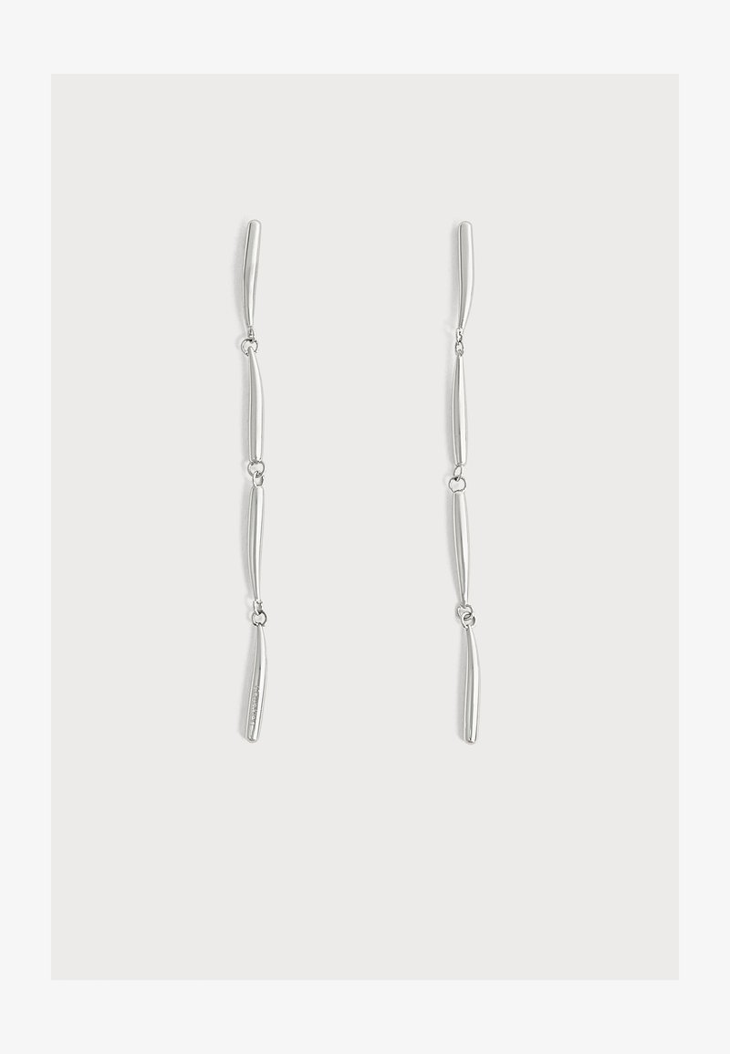 Longues boucles d'oreilles pendantes en argent avec quatre segments fins, légèrement courbés et reliés, sur un fond blanc uni.