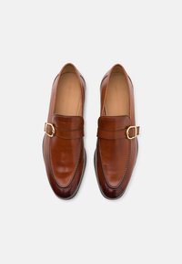 Braune Lederloafers mit abgerundetem Zehenbereich, ausgestattet mit einer dekorativen Schnalle und Nähedetails; glatte Textur und elegantes Design.