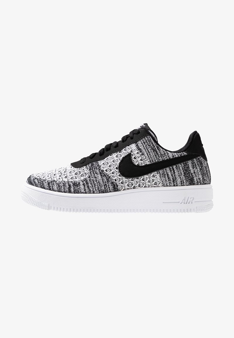 Mustan ja valkoisen neuleen yläosa, jossa on teksturoitu muotoilu; musta swoosh-logo; valkoinen kumipohja; kuusi mustaa silmukkaa nauhoille; tasaiset nauhat.