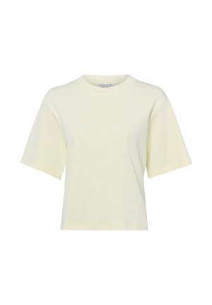 Kremowa koszulka z krótkim rękawem i okrągłym dekoltem, o luźnym kroju, z małą widoczną metką wewnątrz kołnierza.
