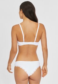 Wit lingerie set met een naadloze bralette met verstelbare bandjes en een bijpassende thong afgewerkt met kant.