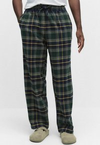 Rutiga pyjamasbyxor med en grön bas och blå och gula linjer, elastisk midja och sidofickor. Mjuk tyg med en avslappnad passform.