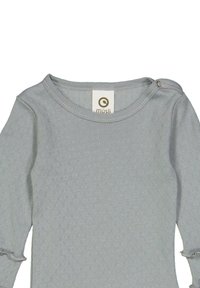 Světle šedý top s dlouhým rukávem a texturovaným vzorem, s kulatým výstřihem a knoflíkovým detailem na rameni pro snadné oblékání. Součástí je štítek značky.