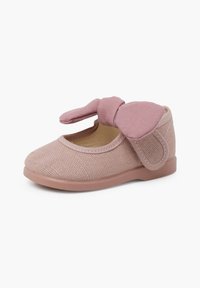 Zapato de tela rosa con una superficie texturizada, puntera redondeada y un gran Laço decorativo en la correa. Presenta una suela de goma suave para mayor agarre.