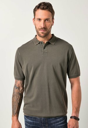 Polo de color verde oliva, fabricado en algodón texturizado, con cuello clásico, tapeta de tres botones y mangas cortas.