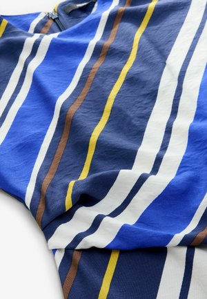 Tessuto blu con strisce verticali bianche, gialle e marroni. Texture morbida, design casual, con chiusura a zip sul collo.