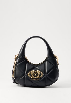 Sac à main noir matelassé de forme arrondie, orné d'un logo doré, avec fermeture éclair et bandoulière chaîne amovible. Texture en cuir lisse.