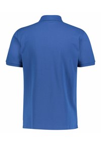 Blå pikétröja med mjuk textur, korta ärmar och klassisk krage. Bakifrån syns en ren design utan mönster eller detaljer.