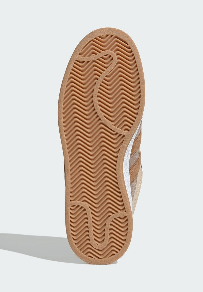 Suola di scarpa in gomma con un motivo a zigzag, di colore senape e con una texture liscia. Include dettagli in marrone chiaro e beige sui lati.