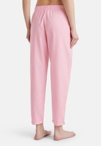 Roze gestreepte loungebroeken met een elastische tailleband en afgegoten enkels, gemaakt van zachte stof, met een licht gestructureerd ontwerp.