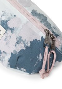 Borsetta con zip in un tessuto testurizzato caratterizzato da un motivo ad acquerello in tonalità di blu e rosa, con zip rosa e dettagli cuciti.