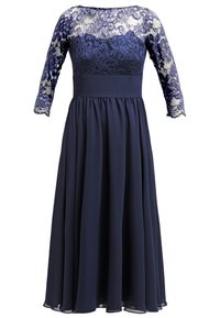 Robe de soirée bleu marine avec corsage et manches en dentelle, taille cintrée et jupe en mousseline fluide, manches en dentelle de longueur trois-quarts.