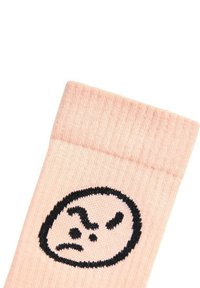 Ljusrosa strumpor av mjukt tyg med ett svart broderat ansikte som har ett argt uttryck. Överkant har en ribbad textur.
