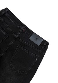 Czarne dżinsy o prostym kroju, z pięcioma kieszeniami i skórzaną metką na pasie. Delikatny czerwony detal haftu widoczny.