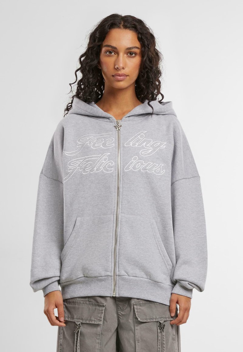 Grauer Reißverschluss-Hoodie mit Kapuze und Kordelzug, Fronttaschen und dekorativer weißer Schrift. Verfügt über eine lockere Passform sowie gerippte Bündchen und Saum.