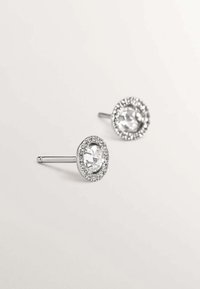 Pendientes de plata con un gran gema clara en el centro, rodeada de un resplandeciente halo de piedras más pequeñas, y un suave poste metálico.