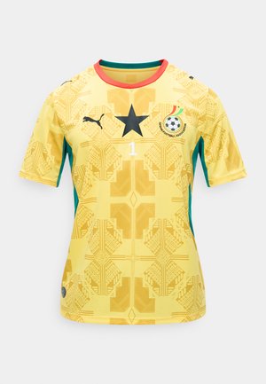 Yellow Ghana football jersey with black star, Puma logo, Ghana Football Association crest, and red collar trim, featuring geometric patterns.