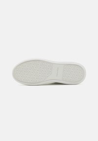 Podeszwa trampka Calvin Klein, biała, wykonana z gumowego materiału, gładka powierzchnia, okrągły wzór tekstury, z odciskiem logo.