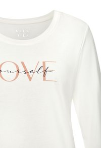 Weißes Langarmshirt mit rundem Ausschnitt und einem Druckdesign in Roségold und schwarzem Text, das "LOVE yourself" lautet.